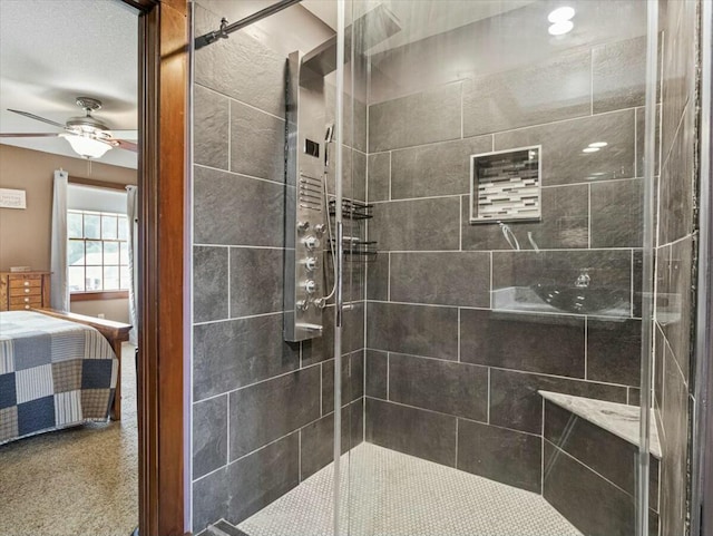 bathroom featuring ceiling fan and a shower with door