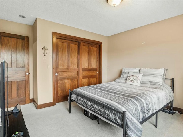 bedroom with a textured ceiling and light carpet