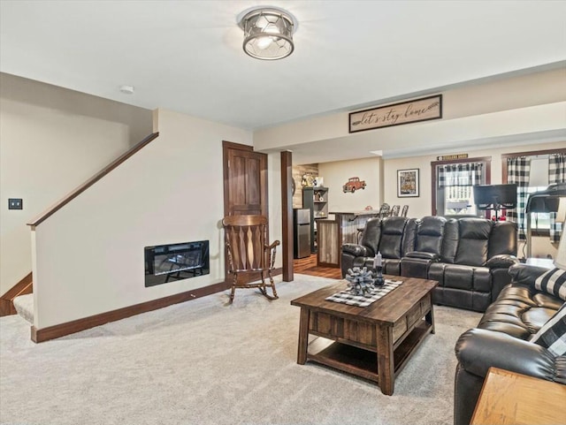 carpeted living room featuring heating unit, bar, and a fireplace