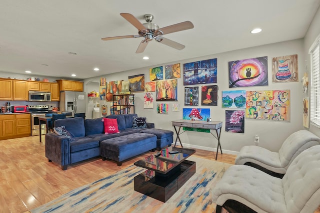 living room with ceiling fan and light hardwood / wood-style flooring