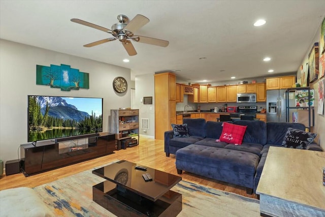 living room featuring ceiling fan and light wood-type flooring