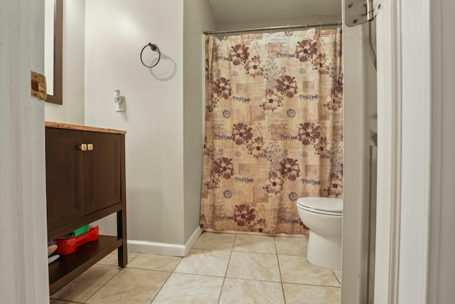 bathroom featuring a shower with curtain, tile patterned floors, and toilet