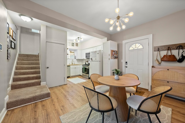 dining area with a wealth of natural light, light hardwood / wood-style flooring, and a chandelier