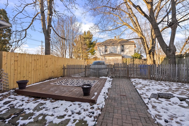 snow covered patio featuring a deck