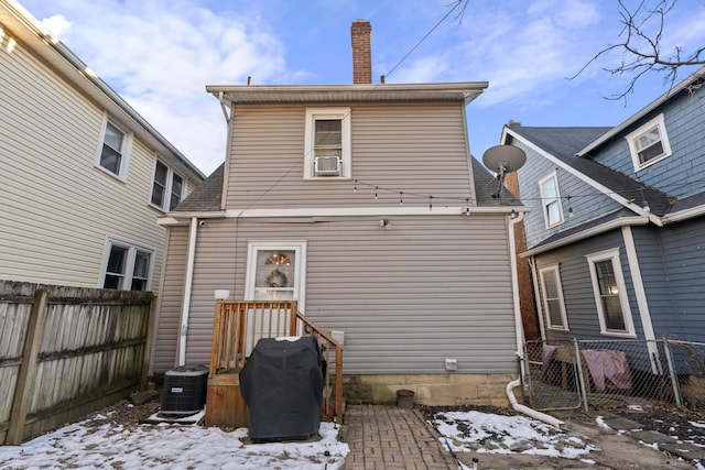 snow covered property featuring central AC unit