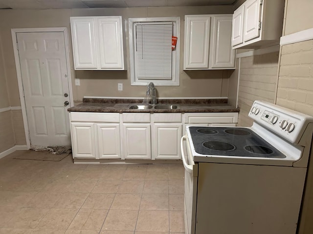 kitchen featuring light tile patterned flooring, white electric range, sink, and white cabinets