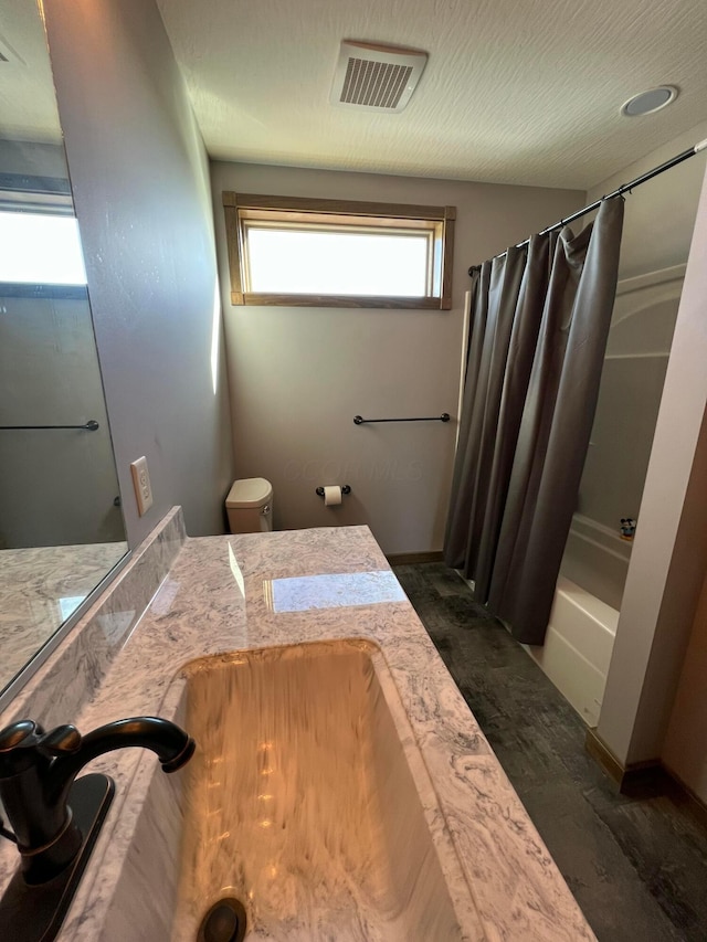 bathroom with toilet, visible vents, shower / tub combo with curtain, and vanity