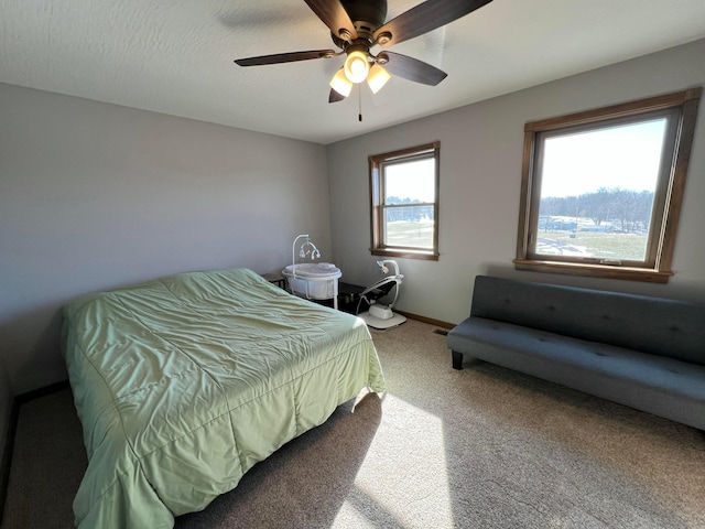 carpeted bedroom with a ceiling fan and baseboards