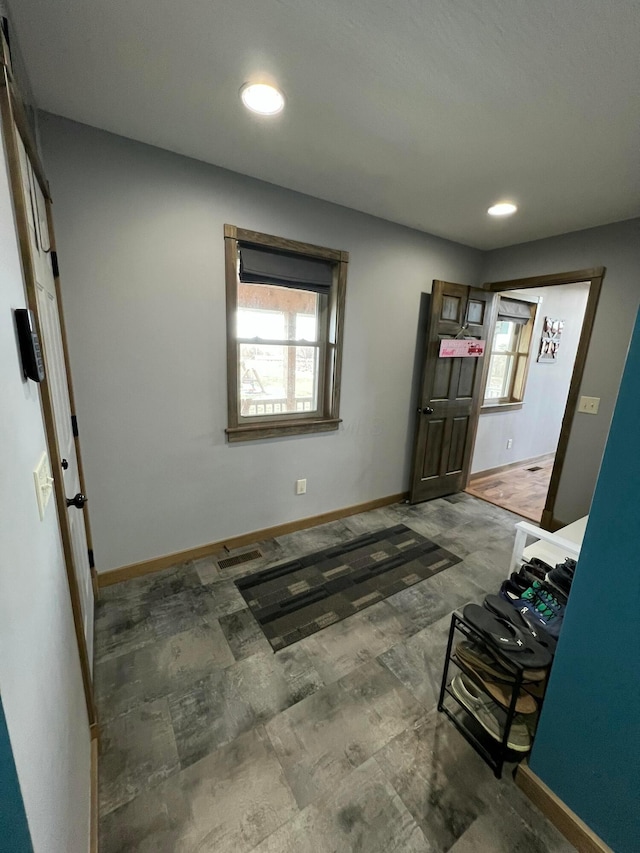 foyer entrance with recessed lighting, a wealth of natural light, and baseboards