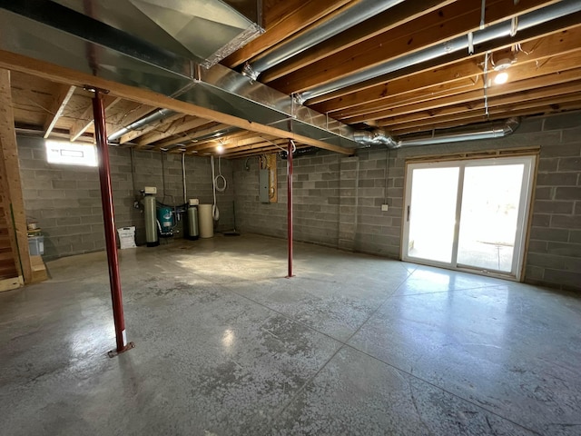 basement with concrete block wall and electric panel