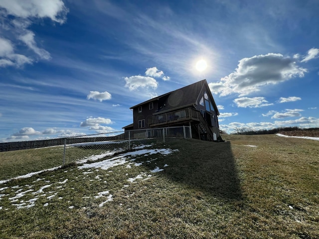 rear view of house with a rural view, a yard, and a deck