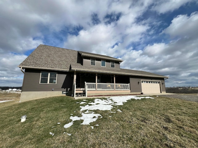 view of front of home featuring a garage, a front lawn, and covered porch