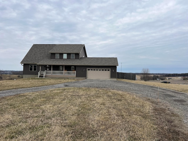 view of front of home with gravel driveway, a shingled roof, covered porch, a garage, and a front lawn