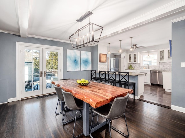 dining area with beamed ceiling, sink, dark hardwood / wood-style flooring, ornamental molding, and french doors