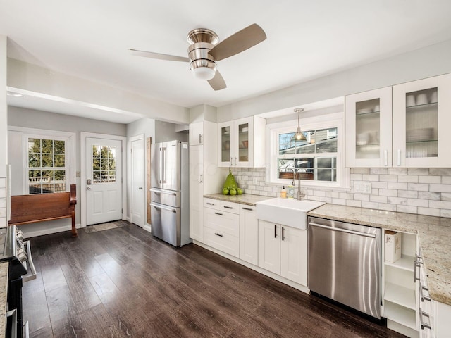 kitchen with light stone countertops, decorative light fixtures, stainless steel appliances, and white cabinets