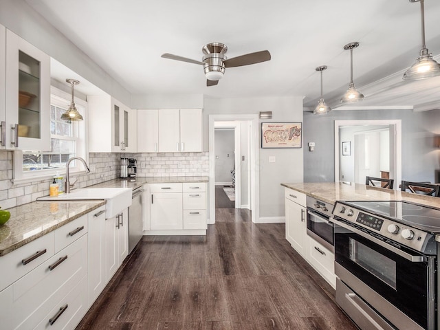 kitchen with hanging light fixtures, stainless steel appliances, and white cabinets