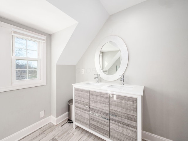 bathroom featuring vanity, vaulted ceiling, and wood-type flooring