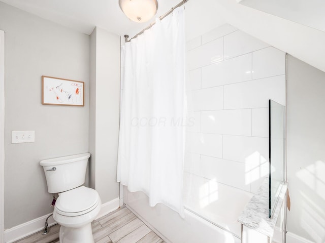 bathroom featuring shower / tub combo, hardwood / wood-style floors, and toilet