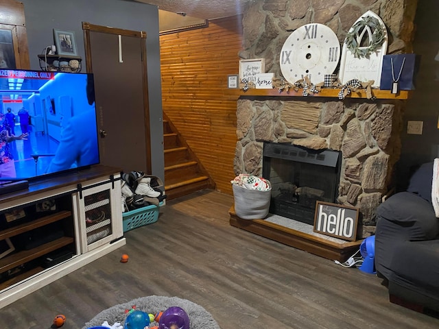 living room featuring wood-type flooring, a textured ceiling, and a fireplace