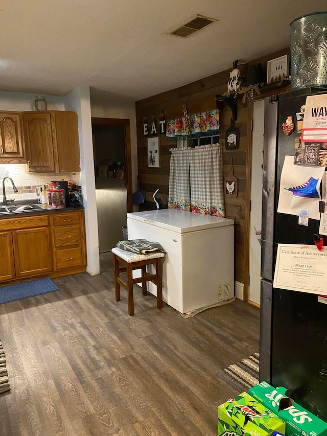 kitchen with tasteful backsplash, dark hardwood / wood-style floors, refrigerator, and sink