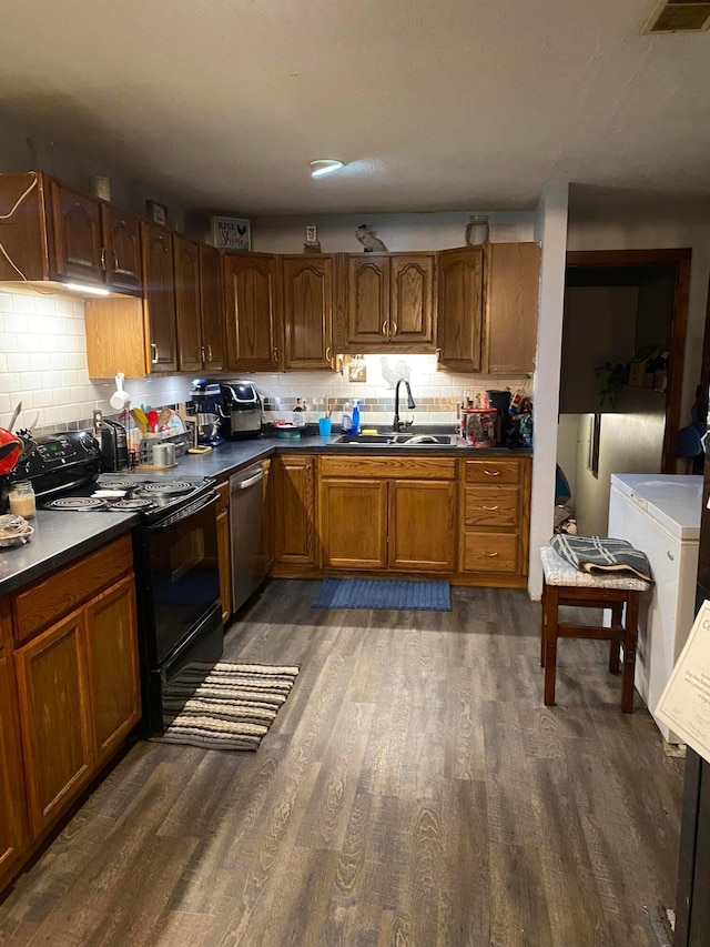 kitchen with sink, stainless steel dishwasher, dark hardwood / wood-style flooring, and black range with electric cooktop