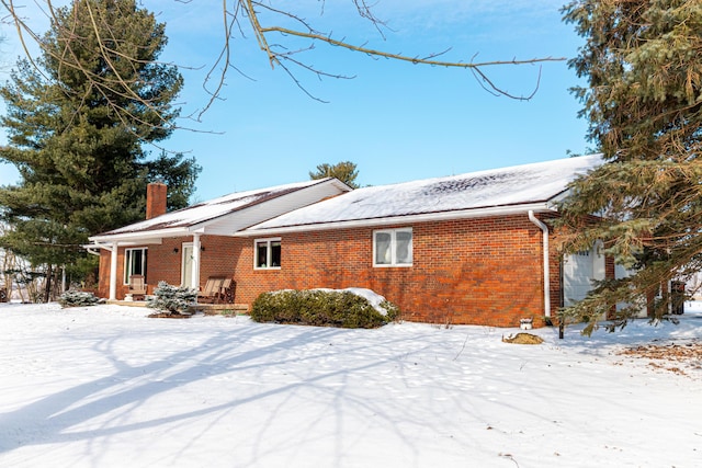 view of snow covered back of property