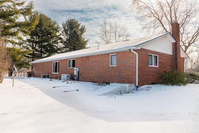 snow covered property featuring cooling unit