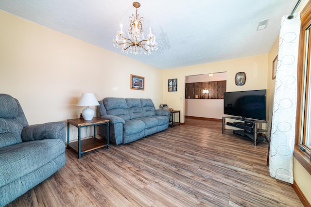 living room featuring an inviting chandelier and hardwood / wood-style flooring