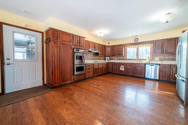 kitchen with tasteful backsplash, dark hardwood / wood-style flooring, and appliances with stainless steel finishes