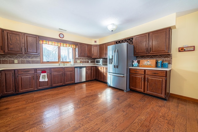 kitchen featuring tasteful backsplash, stainless steel appliances, dark hardwood / wood-style flooring, and sink