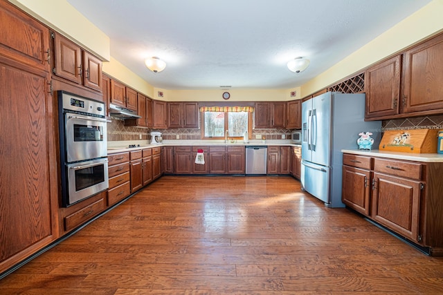 kitchen featuring stainless steel appliances, tasteful backsplash, sink, and dark hardwood / wood-style floors