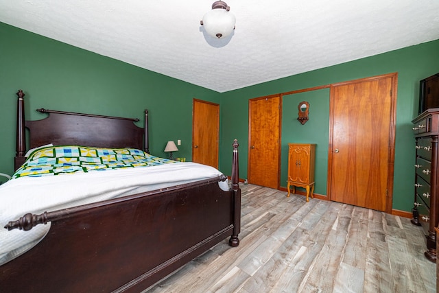 bedroom with light hardwood / wood-style flooring and a textured ceiling