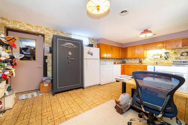 kitchen featuring decorative backsplash, range, washer and clothes dryer, and white fridge