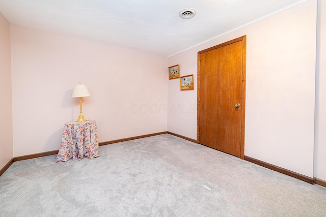 carpeted spare room with crown molding