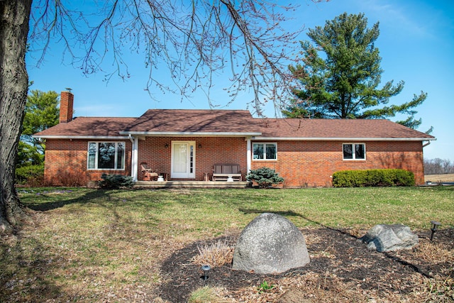 ranch-style house with a front lawn, brick siding, and a chimney