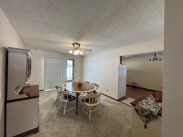 dining space with ceiling fan with notable chandelier and a textured ceiling