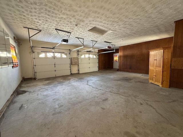 garage with a garage door opener and wooden walls