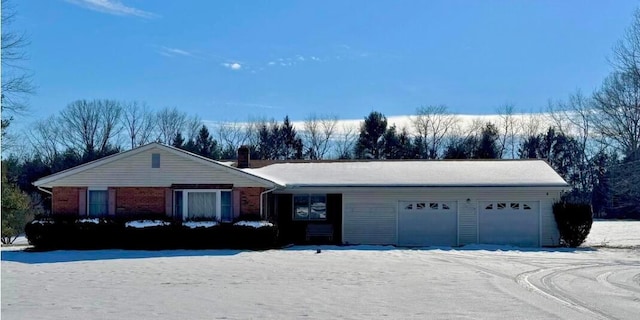 single story home featuring an attached garage, a chimney, and brick siding