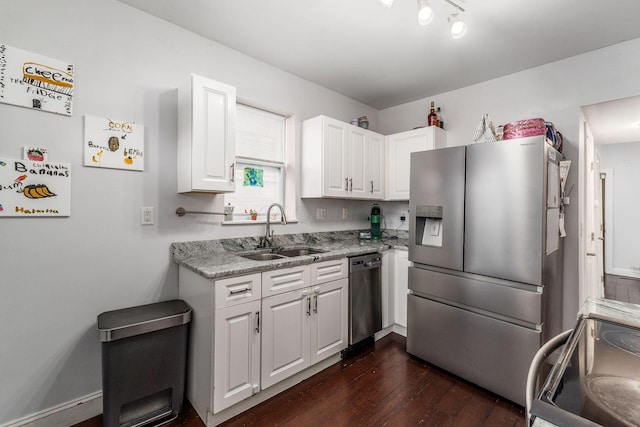 kitchen featuring sink, dark wood-type flooring, white cabinetry, stainless steel appliances, and light stone counters