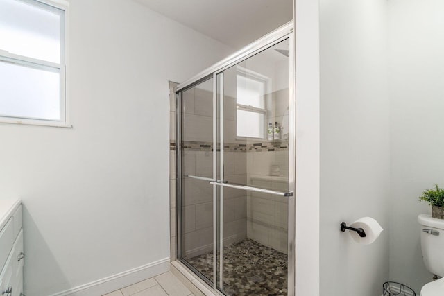 bathroom featuring tile patterned flooring, vanity, a shower with door, and toilet