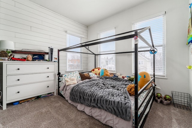 carpeted bedroom with wooden walls