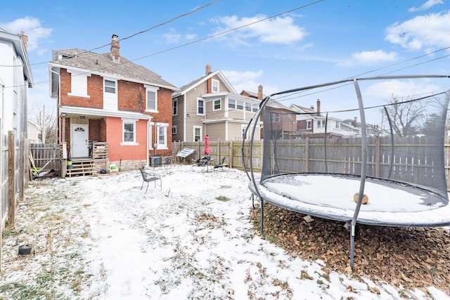 yard covered in snow featuring a trampoline