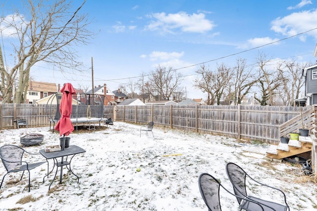 snowy yard featuring a trampoline