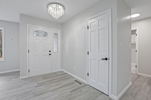 entrance foyer featuring a notable chandelier and light wood-type flooring