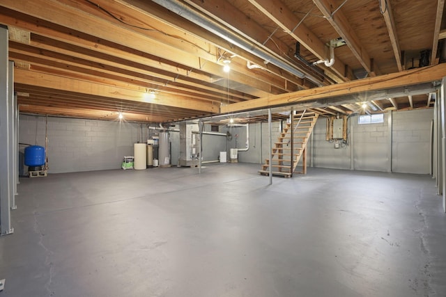 basement with electric panel, heating unit, and gas water heater