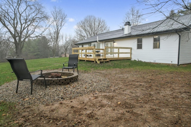 view of yard featuring an outdoor fire pit and a deck