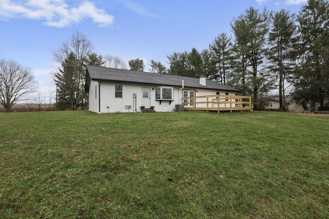 rear view of house featuring cooling unit, a deck, and a lawn