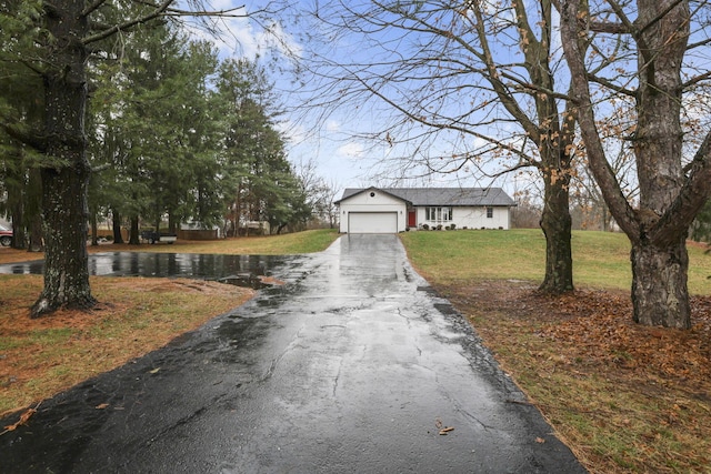 view of front of property featuring a water view, a garage, and a front lawn