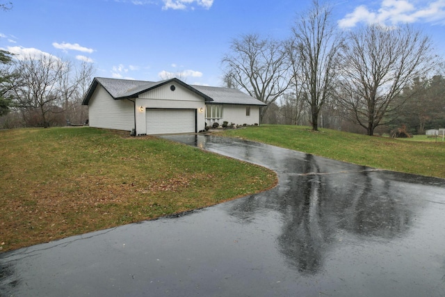 ranch-style house with a garage and a front lawn