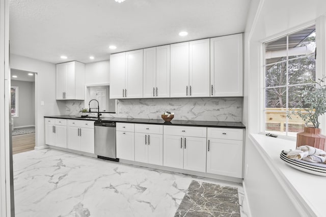 kitchen featuring dishwasher, sink, and white cabinets